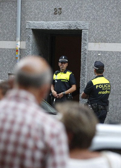 Miembros de la Policía municipal custodian la vivienda donde han sido hallados muertos con signos de violencia un matrimonio de unos 70 años, en el distrito madrileño de Puente de Vallecas.