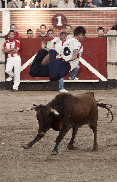 Un mozo salta por encima de una vaquilla en la plaza de San Sebastián de los Reyes.