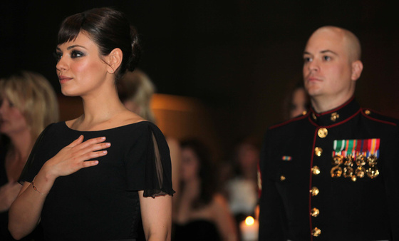 La actriz Mila Kunis y el sargento Scott Moore durante la entonación del himno nacional estadounidense, en el baile de los marines de Carolina del Norte, el 18 de noviembre de 2011