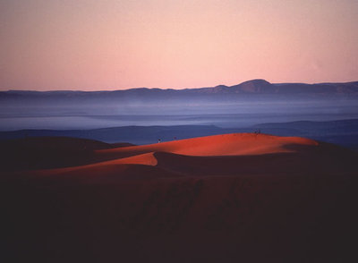 Amanecer en las dunas de Merzouga, al sur de Marruecos; al fondo, la cordillera del Atlas