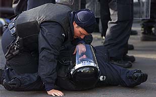 Un policía del Ulster ayuda a un compañero herido durante enfrentamientos con protestantes.