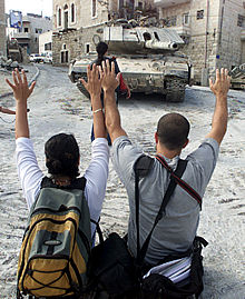   Israel multiplica la ocupación de territorios autónomos palestinos   En la imagen, dos palestinos intentan detener un tanque israelí. (Foto: REUTERS)