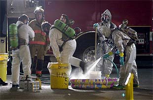 Los bomberos de St. Petersburgo (Florida) se desinfectan en una piscina, a la salida de una oficina de correos.