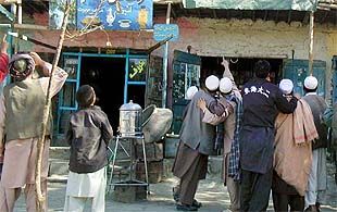 Varios habitantes de Kabul apuntan al cielo, sobrevolado por aviones aliados.