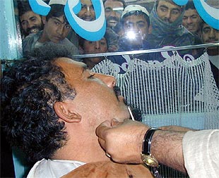 Un peluquero afeita a un kabulí, pocas horas después de la toma de la capital afgana.