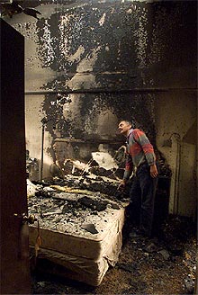 Un hombre muestra cómo el fuego a arrasado su vivienda, situada en una ciudad al este de Sydney.