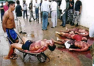 Un policía retira el cadáver de una de las víctimas del motín.