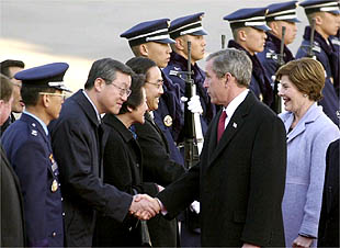 Imagen de Bush y su esposa, Laura, saludando a miembros de la administración surcoreana