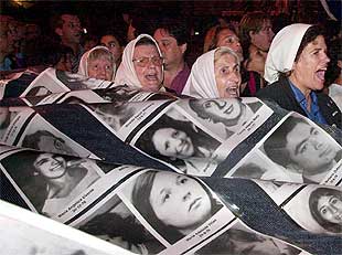 Las madres de la Plaza de Mayo se manifiestan con las fotos de sus desaparecidos.