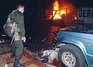 Un policía colombiano observa el cuerpo de una de las víctimas de la explosión en Villavicencio.