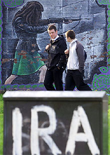 Dos jóvenes pasan ante una pintada de apoyo al IRA, en Belfast (Irlanda del Norte), en una imagen de archivo.