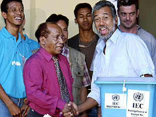 El candidato Xanana Gusmao estrecha la mano a su oponente Francisco Xavier do Amaral tras votar en Dili.