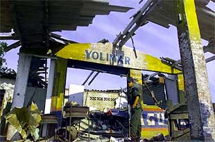 Un policía examina los daños provocados por el atentado contra Uribe.