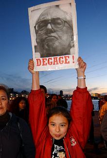 Una mujer levanta un cartel con una foto de Le Pen y la palabra  fuera  en una manifestación en Marsella.