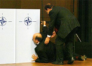 Javier Solana ayuda al ministro belga de Defensa tras desvanecerse antes de la foto de familia.