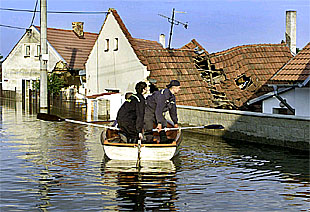 Varios bomberos supervisan los daños provocados por la inundación en la villa Vetrusice, a 30 kilómetros de Praga.