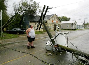 Un vecino de Franklin (Luisiana), contempla un poste eléctrico derribado por el huracán.