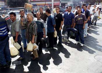 Ciudadanos venezolanos hacen cola en una gasolinera de Caracas para conseguir combustible.