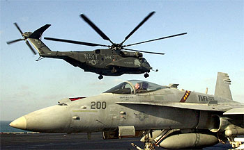 Un helicóptero despega frente a un F-18 en el portaaviones  USS Constellation , en aguas del golfo de Arabia.