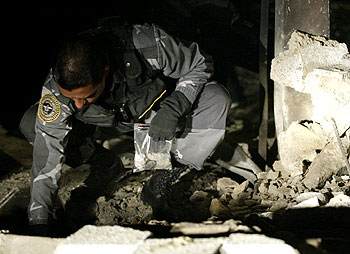 Un policía venezolano recoge restos del muro derruido en la Agencia de Cooperación Española en Caracas.