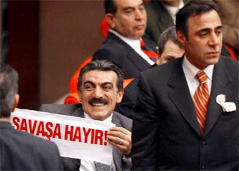 Un diputado del principal partido de la oposición exhibe una pancarta con el 'No a la guerra'.