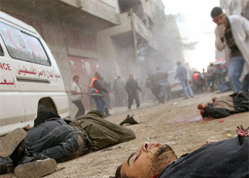 Tres hombres yacen en el suelo de una calle del campo de refugiados del norte de Gaza.