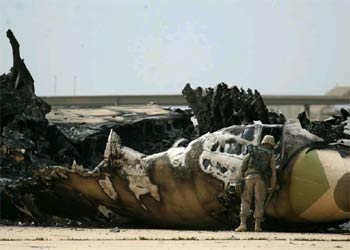 Un soldado estadounidense observa un avión iraquí destruido en la pista del aeropuerto de Bagdad.