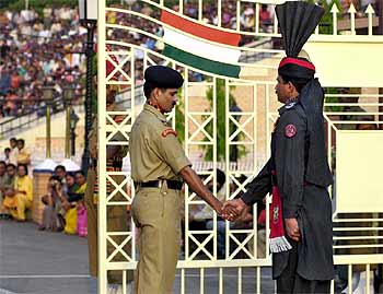 Dos guardias de India y Pakistán se saludan hoy en la frontera de Wagha.