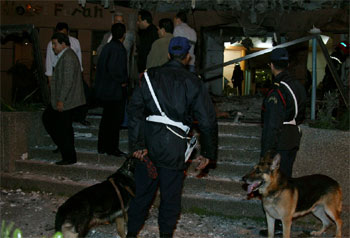 Dos policías inspeccionan los destrozos causados por una bomba en la entrada del Hotel Safir.