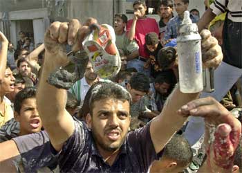 Un palestino muestra con rabia los zapatos y el biberón de la pequeña muerta en el ataque.