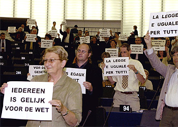 Los diputados de la izquierda muestran pancartas contra Berlusconi con 