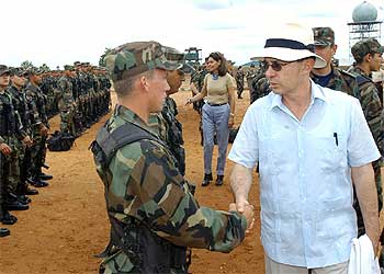 El presidente colombiano Álvaro Uribe y la ministra de Defensa Marta Lucía Ramírez (al fondo) saludan a soldados al su llegada a Arauca.