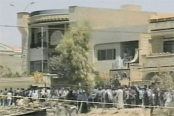 Decenas de iraquíes se amontonan en los alrededores de la villa de Mosul atacada hoy por tropas estadounidenses.