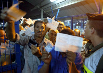 Un grupo de trabajadores exhibe su documentación al entrar en Israel.