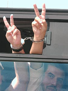Presos palestinos hacen el signo de la victoria al partir de la cárcel de Megiddo rumbo a su libertad en Cisjordania.