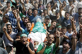 Cientos de palestinos portan el cadáver de Ahmed Shitawi durante su funeral en Gaza.