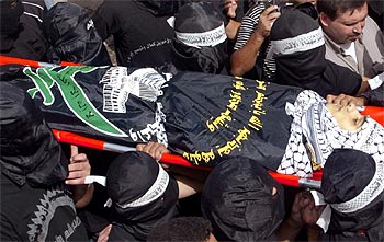 Palestinos armados portan el cuerpo sin vida de Fadi Abou Zant durante su entierro en Nablús.
