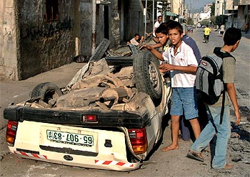 Unos niños palestinos miran el estado en el que quedó el coche bomba desactivado cerca de Nablús.