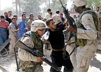 Dos soldados estodounidenses detienen a un antiguo miembro del Ejército iraquí en Bagdad.