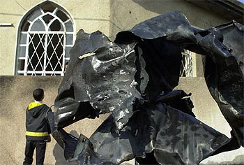 Un niño iraquí, junto al generador de la mezquita Ahbab al Mustafá de Bagdad, destrozado por la explosión.