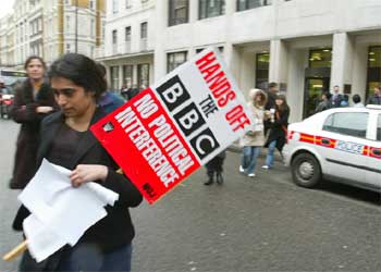 Un empleado de la BBC, a las puertas de la sede de la cadena en Londres con un cartel en el que se lee: 