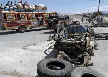 Un autobús pasa junto a una de las barreras que bloquean el acceso a Puerto Príncipe.