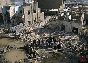 Un grupo de iraquíes contemplaba esta mañana los destrozos causados por el coche bomba que explotó anoche en el centro de Bagdad.