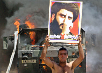 Un miembro de la milicia chií muestra un retrato del líder radical Al Sáder, en Bagdad.