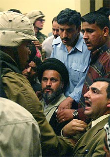 Soldados estadounidenses custodian al lugarteniente de Al Sáder en Bagdad, en el centro de la imagen.