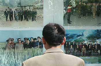 Un chino mira un panel con fotos del  gran líder  en la puerta de la embajada de Corea del Norte en Pekín.