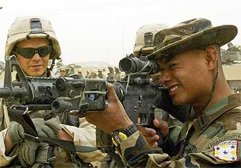 Un soldado hondureño muestra sus armas a un militar estadounidense en la base de Nayaf.