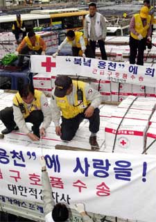 Miembros de Cruz Roja preparan en Seúl camiones de ayuda humanitaria para Corea del Norte.