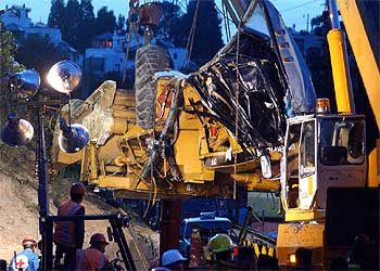 Una grúa ayuda a retirar la excavadora de 40 toneladas que cayó de una altura de más de cinco metros.