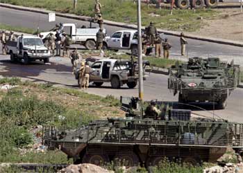 Soldados de la Coalición inspeccionan la carretera de Mosuñ donde al menos dos guardias de seguridad extranjeros han muerto por la explosión de una bomba.